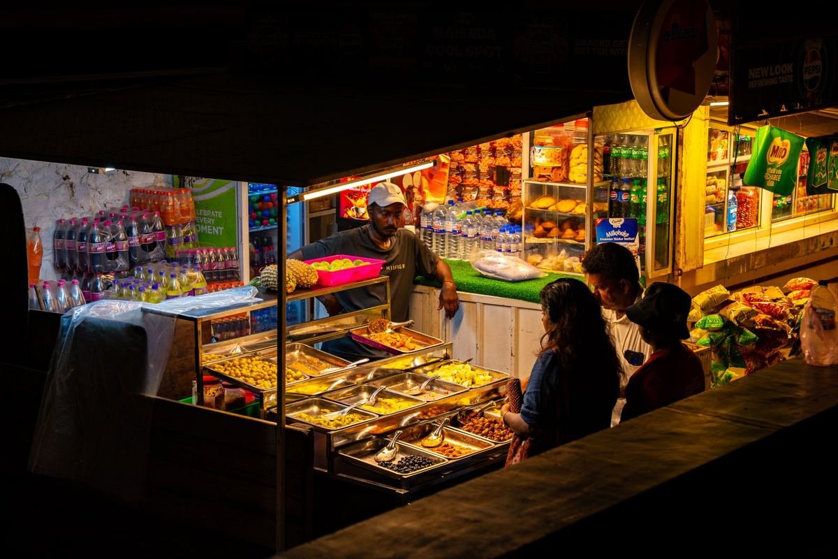 A food stall at night under bright electric lights