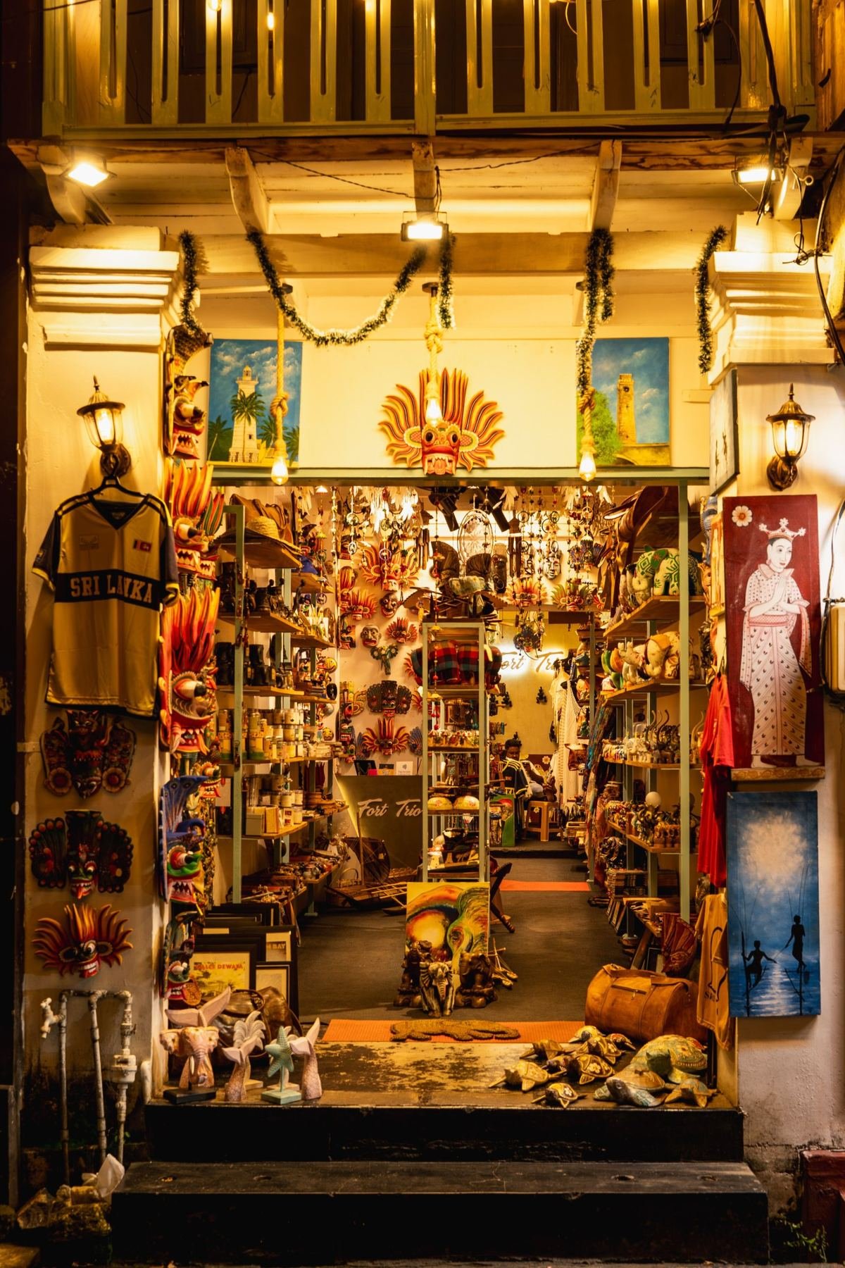 A craft shop lit warmly in the evening, hung with painted masks